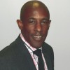 Image of Carl Nandoo, in a suit, smiling